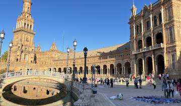 Plaza with historic buildings and people walking around.