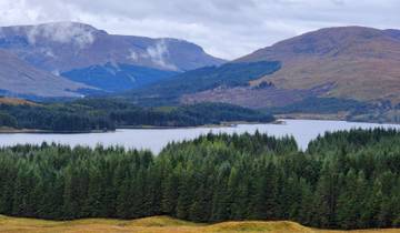 Scenic view of a lake surrounded by lush hills.