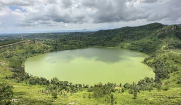 A large circular lake surrounded by green hills.