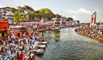 Vibrant riverside scene with people performing rituals.