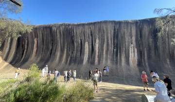 People exploring Wave Rock in Australia.