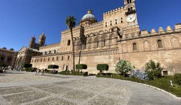 Palermo Cathedral with people walking around the historical site.