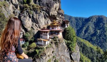 A person looking out at the Taktsang Monastery perched on a cliff.