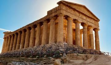 An ancient Greek temple with Doric columns under a clear sky.