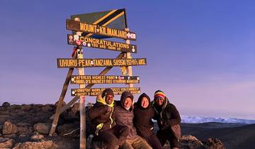 Group celebrating at the summit of Mount Kilimanjaro.