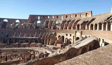 Interior of the Colosseum in Rome, sunlight casting shadows.