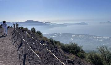 View from a mountain trail overlooking the Italian coastline with person walking.