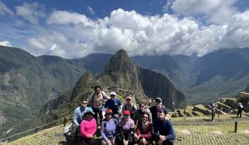 Group of people posing with Machu Picchu in the background.