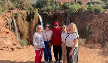 Group of people in front of waterfalls.