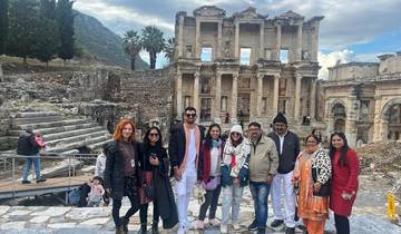 Group of tourists posing in front of ancient ruins.