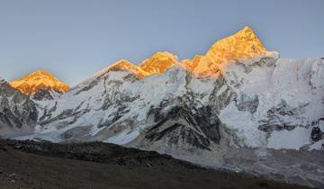 Sunlit snow-covered mountain peaks with dramatic lighting.