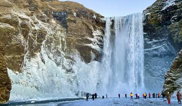 Massive waterfall surrounded by ice and snow.