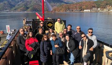 Group on a boat with a scenic lake and mountain view.