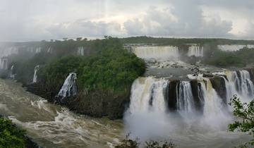 Panoramic view of Iguazu Falls with lush green surroundings.
