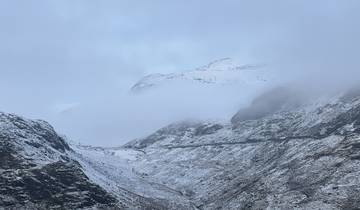 Snow-covered mountains with a road and foggy atmosphere