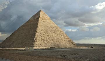 Pyramid with partially cloudy sky in the background.