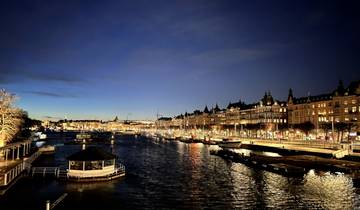 Night view of a city canal with lights reflecting on the water.
