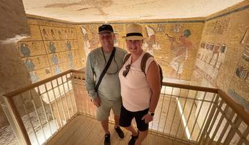 Couple standing inside an ancient structure decorated with murals.