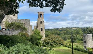 Historic stone castle with tourists exploring.