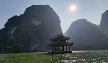 Pagoda on water with surrounding limestone mountains.