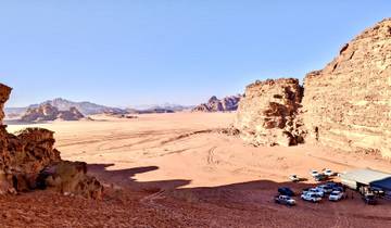 Desert landscape with vehicles and rock formations.
