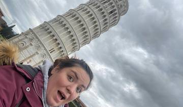 Person posing in front of the Leaning Tower of Pisa.