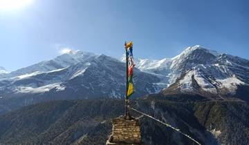 Snow-capped mountain peaks with prayer flags.