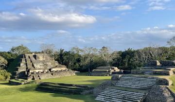 Ancient ruins with stepped pyramid structures under a clear blue sky