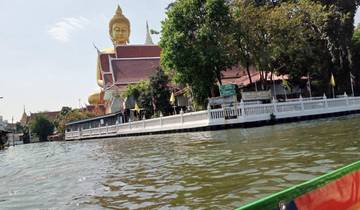 Golden Buddha statue next to a waterway.