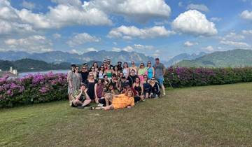 Large group with mountains and flowers in the background.