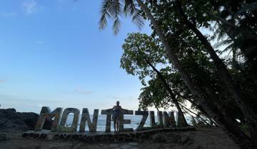 Montezuma sign with palm trees and a person.