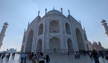 The Taj Mahal with many visitors around, seen on a bright day.