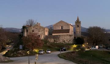 Stone structure with a bell tower at dusk.