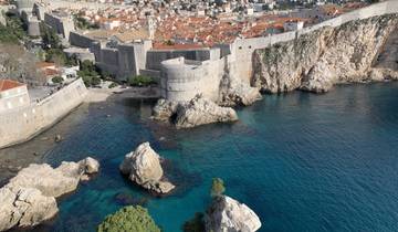 Rocky coastline with fortifications and clear water.
