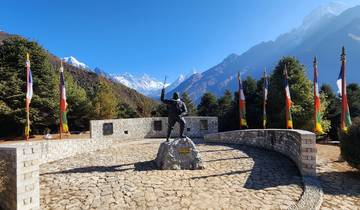 Monument with flags and snow-capped mountains.