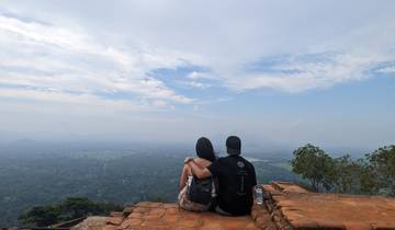 Couple sitting on a viewpoint with a vast landscape ahead.