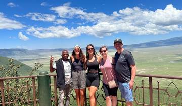 Group of people posing with a scenic landscape in the background.