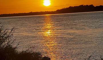 Sunset over a river with reflections on the water.