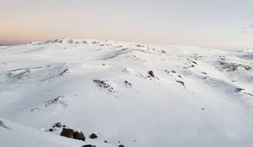Vast snowy landscape under a slightly pink sky.