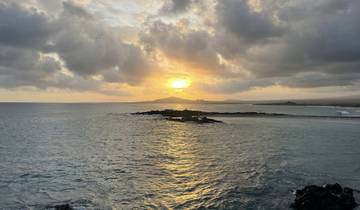 Sunset view over the ocean with clouds creating a dramatic sky.