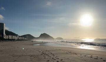 Expansive beach with sun setting in the horizon.