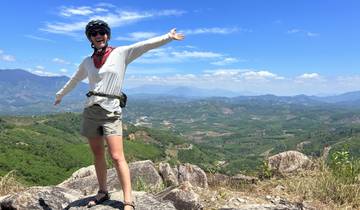 A person with open arms enjoying a mountainous landscape.
