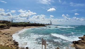 Coastline with rocky beach and distant city skyline.