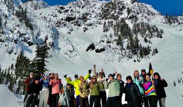 Group of people celebrating outdoors with snowy mountains in the background.