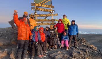 Group celebrating at the peak of Mount Kilimanjaro.