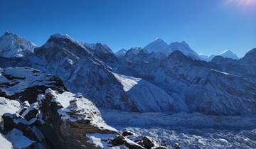 Snow-covered mountains and glacier under a clear sky.