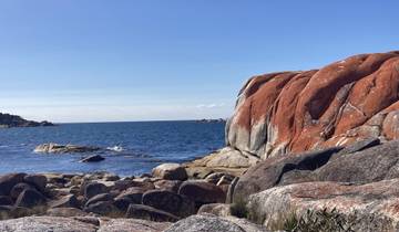 Rock formations by the sea with clear skies.