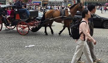 A horse-drawn carriage with people walking in a cobblestone square.