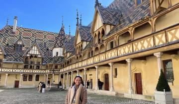 Person standing in front of a historical building with decorative tiles.