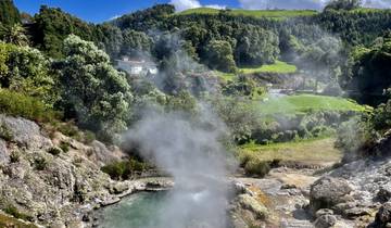 Hot springs with steam rising out of the ground.